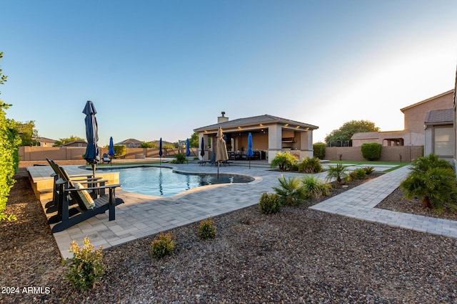 view of swimming pool featuring a fenced backyard and a patio area