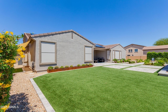 view of front facade featuring a patio, stucco siding, and solar panels