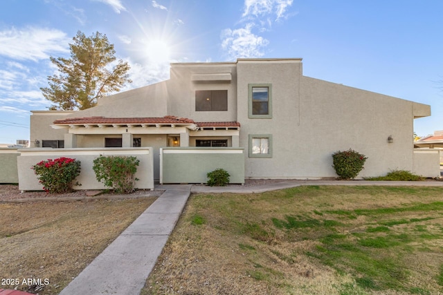 southwest-style home with a fenced front yard and stucco siding