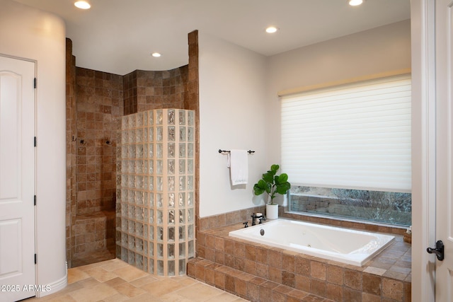 bathroom with stone finish flooring, a walk in shower, a bath, and recessed lighting