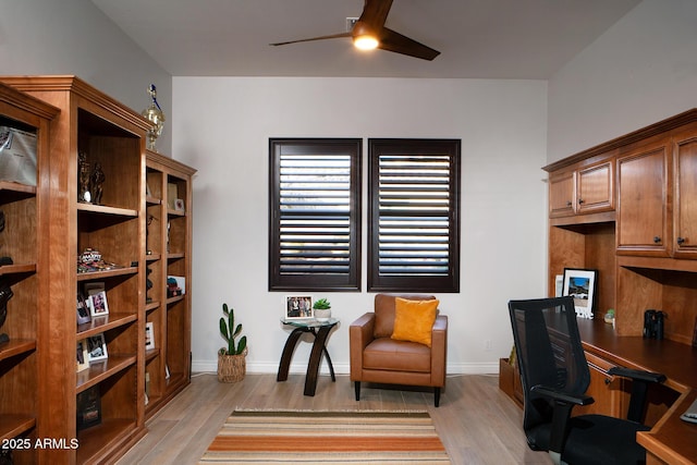 office area with light wood-type flooring, ceiling fan, and baseboards