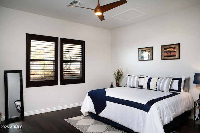 bedroom with ceiling fan, visible vents, baseboards, dark wood finished floors, and attic access