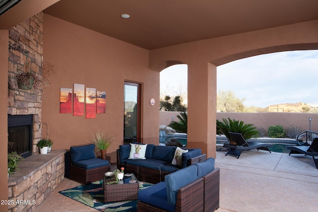 view of patio featuring fence and an outdoor living space with a fireplace