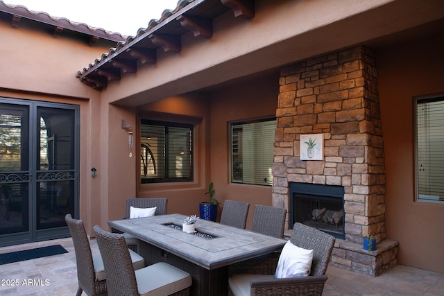 view of patio with outdoor dining space and an outdoor stone fireplace