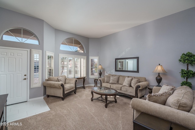 carpeted living room with a high ceiling