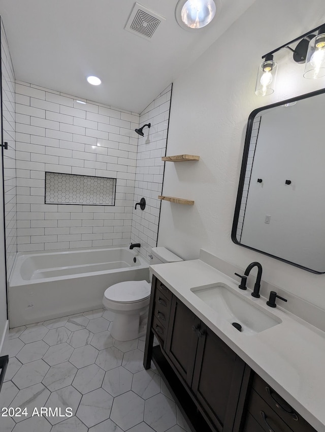 full bathroom with toilet, vanity, tile flooring, and tiled shower / bath