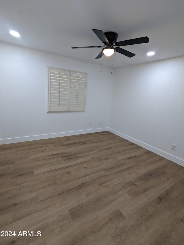 spare room with ceiling fan and dark wood-type flooring