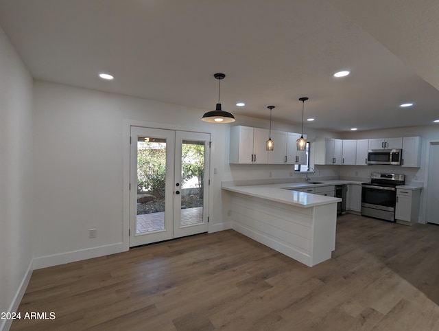 kitchen featuring wood-type flooring, stainless steel appliances, and kitchen peninsula