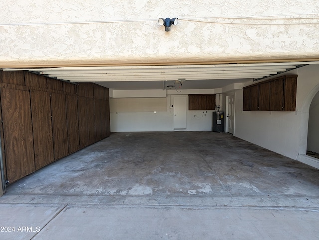 garage featuring electric water heater and a garage door opener