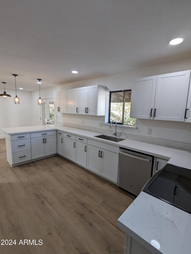 kitchen featuring decorative light fixtures, white cabinetry, stainless steel dishwasher, and sink