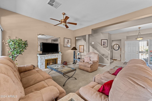 carpeted living room featuring ceiling fan and a fireplace