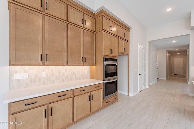 kitchen featuring double oven and tasteful backsplash