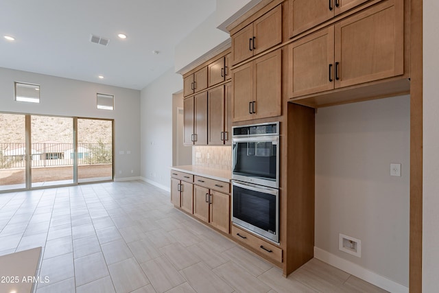 kitchen with decorative backsplash and stainless steel double oven