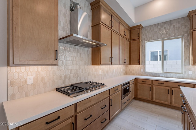 kitchen with backsplash, stainless steel appliances, and wall chimney range hood