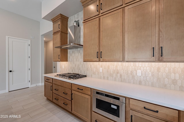 kitchen with decorative backsplash, wall chimney exhaust hood, and stainless steel gas stovetop