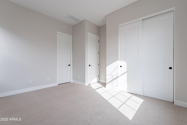 unfurnished bedroom with light carpet and a closet