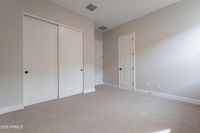 unfurnished bedroom featuring a closet and light colored carpet