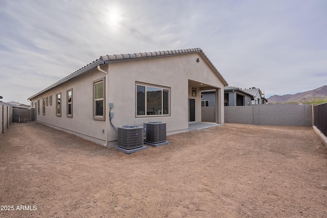 rear view of house featuring a mountain view, a patio, and central AC