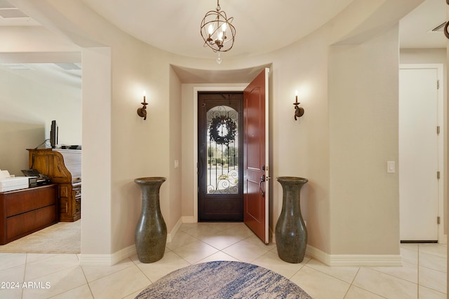 tiled entrance foyer with a notable chandelier