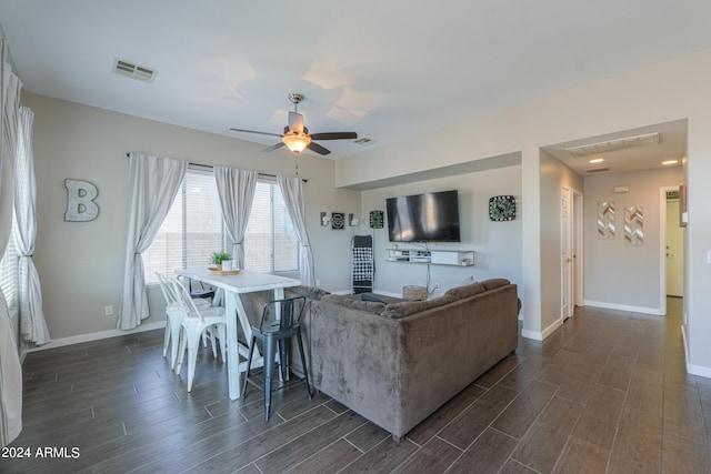 living area with wood tiled floor, visible vents, and baseboards