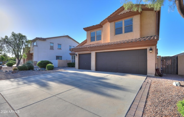 view of front facade featuring driveway, an attached garage, a tile roof, and stucco siding