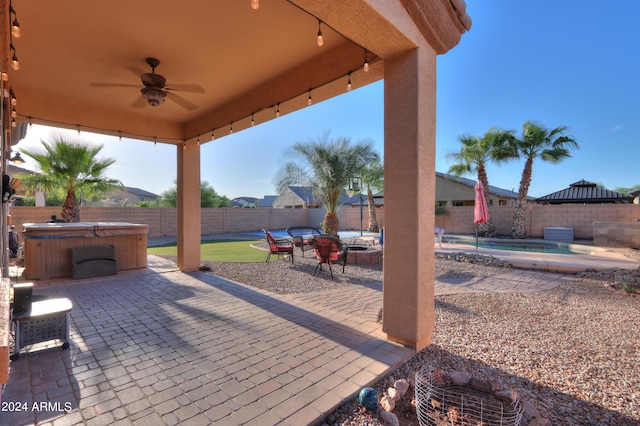 view of patio with a ceiling fan, a pool, a fenced backyard, and a hot tub