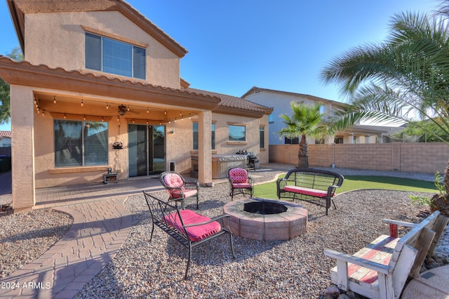 view of patio featuring an outdoor fire pit, a ceiling fan, an outdoor kitchen, and a fenced backyard