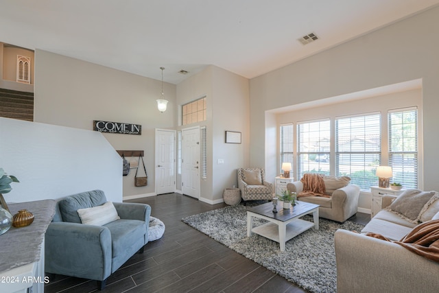 living room featuring baseboards, a high ceiling, visible vents, and dark wood-type flooring