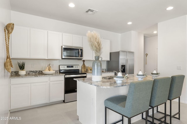 25461 W Graham Trl, Buckeye, AZ 85326 - kitchen featuring white cabinets, visible vents, a center island with sink, and appliances with stainless steel finishes