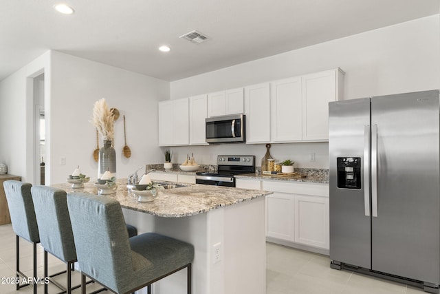 25461 W Graham Trl, Buckeye, AZ 85326 - kitchen featuring white cabinetry, light stone countertops, visible vents, stainless steel appliances, and a sink