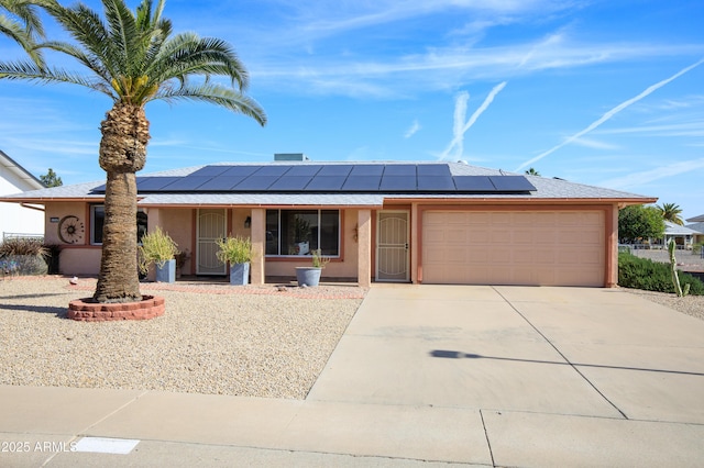 single story home featuring a garage and solar panels