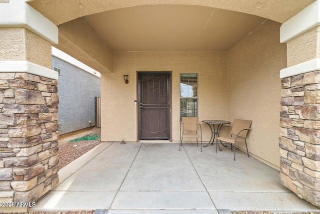 view of exterior entry with a patio