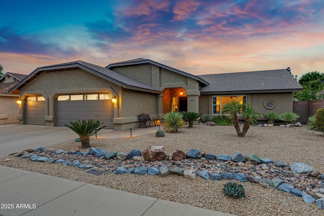 ranch-style home featuring a garage, driveway, and stucco siding