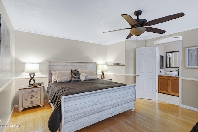 bedroom with light wood finished floors, baseboards, and ornamental molding
