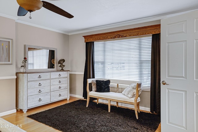 living area featuring ceiling fan, baseboards, a wealth of natural light, and ornamental molding