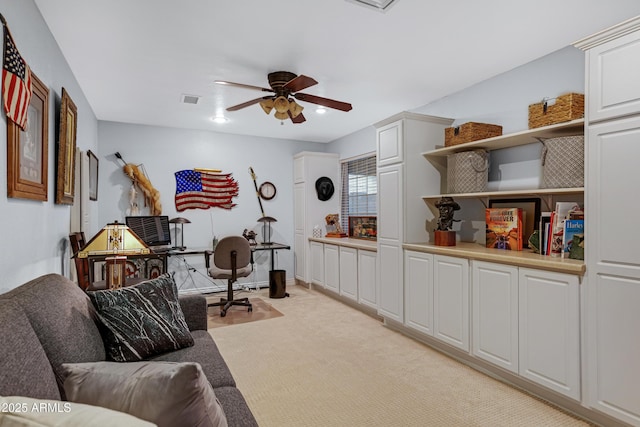 office featuring a ceiling fan, visible vents, and light colored carpet