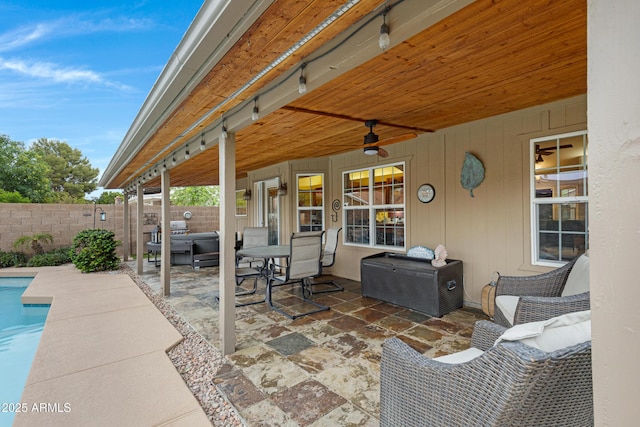 view of patio / terrace featuring a jacuzzi, a fenced backyard, a ceiling fan, and a fenced in pool