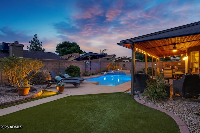 pool at dusk featuring a lawn, a fenced backyard, a fenced in pool, and a patio area