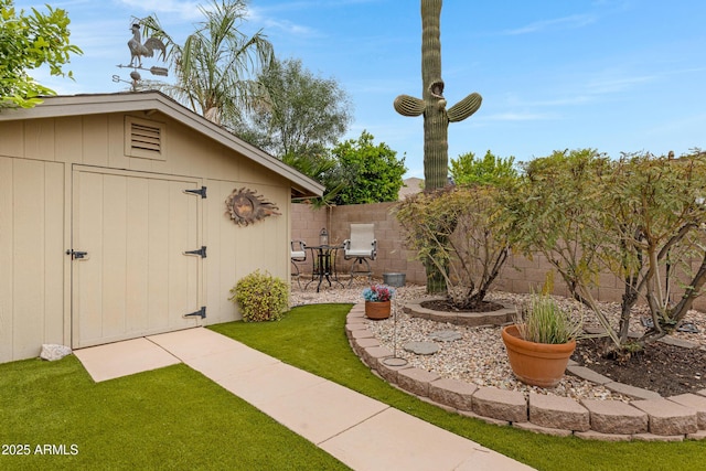 view of yard with a fenced backyard, a storage unit, an outbuilding, and a patio