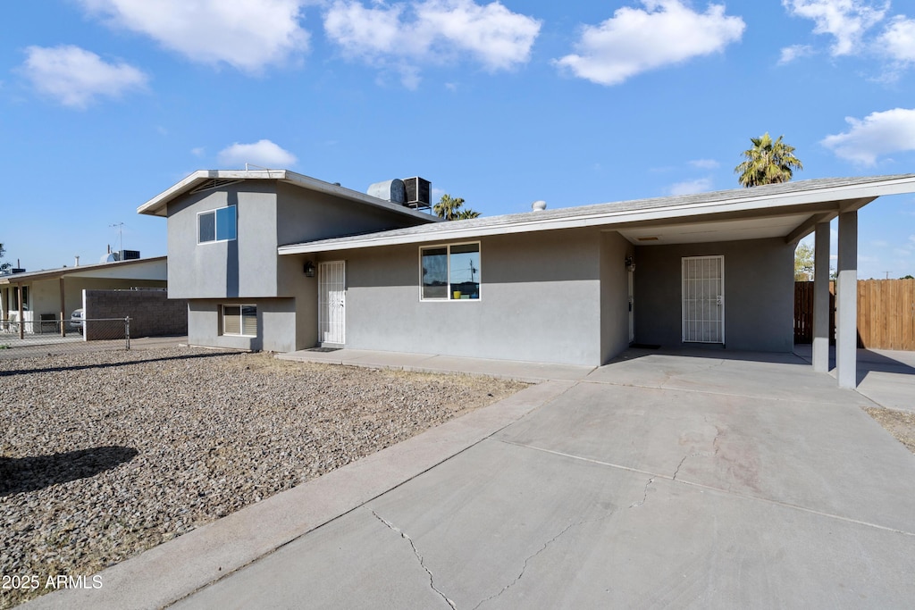 view of front of home featuring central air condition unit and a carport