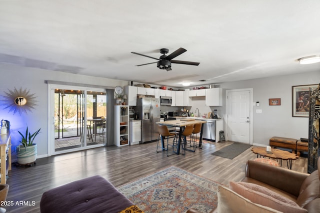 living room featuring ceiling fan, hardwood / wood-style floors, and sink