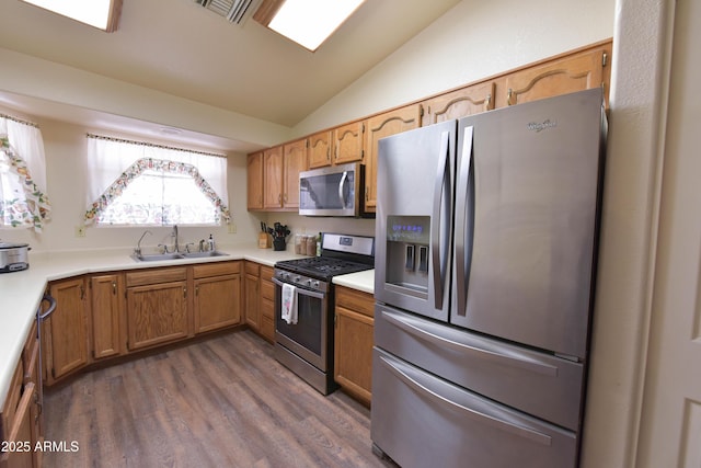 1219 E Avenida Isabela, Casa Grande, AZ 85122 - kitchen featuring stainless steel appliances, a sink, lofted ceiling, dark wood-style flooring, and light countertops