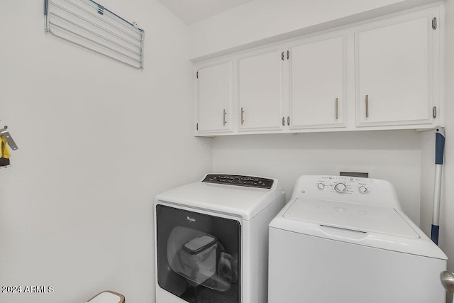 clothes washing area featuring cabinets and separate washer and dryer