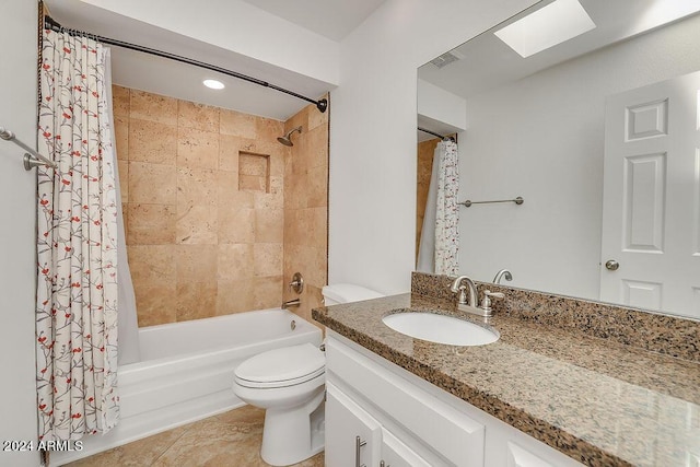 full bathroom with shower / tub combo, a skylight, tile patterned floors, vanity, and toilet