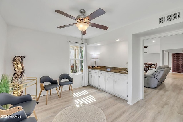 interior space with ceiling fan, sink, and light hardwood / wood-style floors