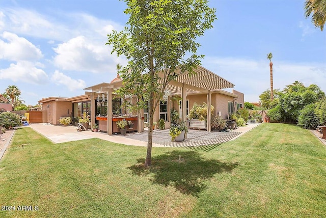 back of property featuring a pergola, a hot tub, a patio area, and a lawn