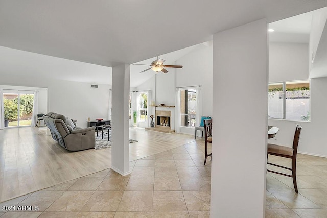 living room with light hardwood / wood-style floors, high vaulted ceiling, and ceiling fan