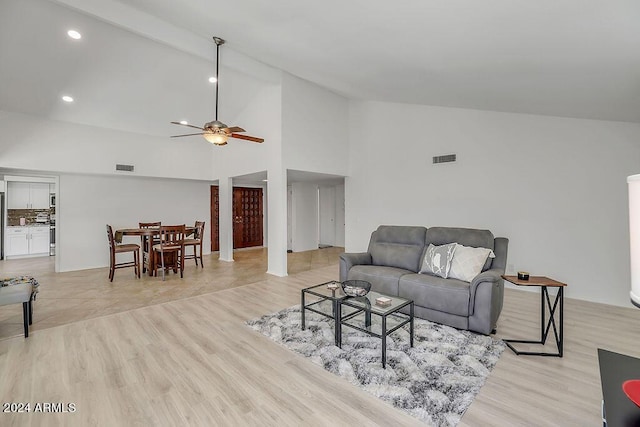 living room featuring light hardwood / wood-style flooring, high vaulted ceiling, and ceiling fan