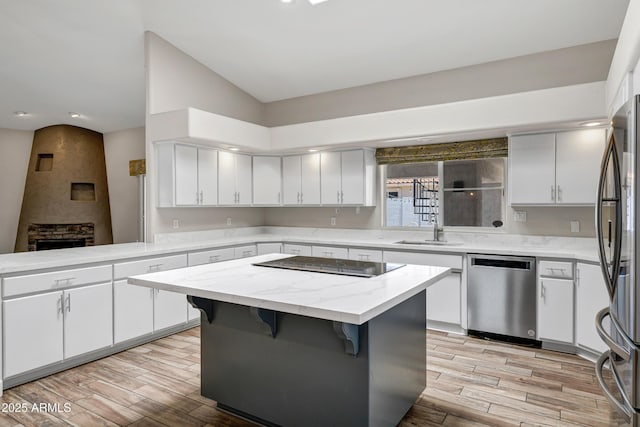 5345 E Mclellan Rd Unit 123, Mesa, AZ 85205 - kitchen with appliances with stainless steel finishes, a sink, light wood-type flooring, a center island, and vaulted ceiling