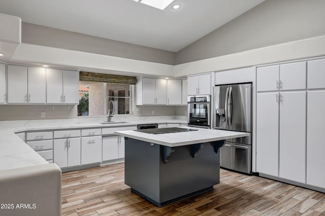 5345 E Mclellan Rd Unit 123, Mesa, AZ 85205 - kitchen with stainless steel appliances, a sink, vaulted ceiling, light wood-style floors, and white cabinets